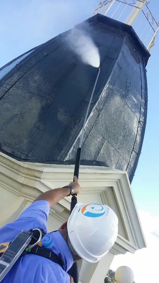 QCC specialist performing high-access cleaning on telecommunications infrastructure